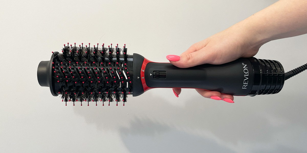 Hand with pink nails holding Revlon One-Step Volumizer Plus 2.0