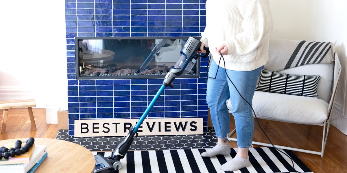 Person using corded vacuum on area rug