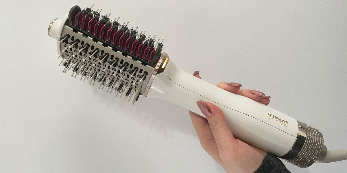 Hand holding Shark HT202 SmoothStyle Heated Comb + Blow Dryer Brush